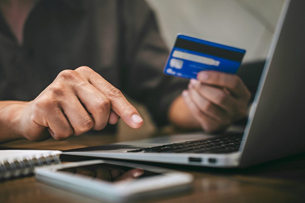 Businessman holding credit card and typing on laptop for online